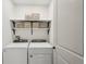 Functional laundry room with modern washer and dryer units, and storage shelves at 1876 Livingstone St, Sarasota, FL 34231