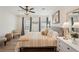 Bright main bedroom featuring a ceiling fan, wood floors, and abundant natural light from the large windows at 1876 Livingstone St, Sarasota, FL 34231