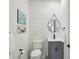 Powder room featuring white textured tile, gray vanity, and decorative paintings at 1876 Livingstone St, Sarasota, FL 34231