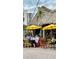 Lively outdoor restaurant with thatched roof, colorful chairs, and sunny yellow umbrellas on a casual afternoon at 1876 Livingstone St, Sarasota, FL 34231