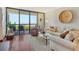 Charming living room with hardwood floors, stylish furniture, and a sliding glass door to the balcony at 1930 Harbourside Dr # 136, Longboat Key, FL 34228
