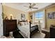 Comfortable bedroom with a dark wood bed, plush bedding, and a window with sheer curtains for soft natural light at 2512 61St E Ave, Ellenton, FL 34222
