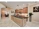 Bright kitchen with tile flooring, an island with granite countertops, and wooden cabinets at 2512 61St E Ave, Ellenton, FL 34222