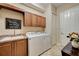 Bright laundry room features modern washer and dryer, sink, storage cabinets, and tile flooring at 2512 61St E Ave, Ellenton, FL 34222