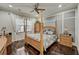Elegant bedroom with a four-poster bed, dark wood floors, and recessed lighting creating a luxurious retreat at 2512 61St E Ave, Ellenton, FL 34222