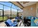 Relaxing screened-in patio with comfortable seating, ceiling fan, and views of the backyard and neighborhood at 2512 61St E Ave, Ellenton, FL 34222