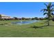 Scenic pond view with fountain features surrounded by lush green lawns and tropical landscaping under a clear blue sky at 2512 61St E Ave, Ellenton, FL 34222