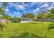 Lush backyard with a well-maintained lawn and a view of the home's exterior with a covered porch at 2566 Tulip St, Sarasota, FL 34239