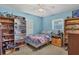 Blue bedroom with ceiling fan, window, and shelving units displaying an array of collectibles at 2566 Tulip St, Sarasota, FL 34239