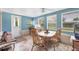 Sunlit dining area with a wooden table, cozy seating, adjacent to an exit with a backyard view at 2566 Tulip St, Sarasota, FL 34239