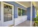 Close-up showcasing the home's inviting front porch with a white door, blue walls, and brick accents at 2566 Tulip St, Sarasota, FL 34239