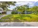 Charming single-story home with a well-manicured lawn and mature trees, creating a welcoming curb appeal at 2566 Tulip St, Sarasota, FL 34239