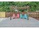 Relaxing backyard pergola with gray deck and chairs, surrounded by a privacy fence and lush landscaping at 2905 Bougainvillea St, Sarasota, FL 34239