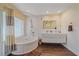 Bright bathroom boasts a soaking tub, tiled walls, and a modern double sink vanity at 2905 Bougainvillea St, Sarasota, FL 34239
