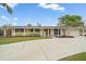 Charming single-story home with a well-manicured lawn, palm trees, and a concrete driveway at 2905 Bougainvillea St, Sarasota, FL 34239
