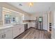 Well-lit kitchen with stainless steel appliances, white cabinets, a mosaic backsplash, and modern flooring at 2905 Bougainvillea St, Sarasota, FL 34239