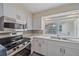 Bright kitchen featuring stainless steel appliances, white cabinets, and a view of the backyard from the sink at 2905 Bougainvillea St, Sarasota, FL 34239