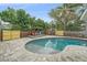 Backyard pool featuring brick pavers, lush landscaping and a pergola with colorful Adirondack chairs at 2905 Bougainvillea St, Sarasota, FL 34239
