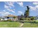 Well-maintained backyard with a large lawn, landscaping, and a screened-in pool and patio area at 31 Bunker Rd, Rotonda West, FL 33947