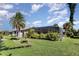 Large landscaped backyard with a screened-in pool and a mix of sunny and shady areas at 31 Bunker Rd, Rotonda West, FL 33947