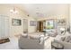Cozy living room with neutral décor, tile flooring, ceiling fan, and sliding glass doors leading to a screened patio with pool view at 31 Bunker Rd, Rotonda West, FL 33947
