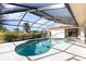 Outdoor view of the screened-in pool and lanai surrounded by lush landscaping and sunny skies at 31 Bunker Rd, Rotonda West, FL 33947