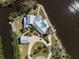 Aerial view of waterfront home featuring pool, dock, and lush landscaping on private point at 336 S Orchid Dr, Ellenton, FL 34222