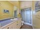 Well-lit bathroom featuring single vanity, large mirror and sliding glass doors on walk-in shower at 336 S Orchid Dr, Ellenton, FL 34222