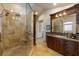 Luxurious bathroom features tiled shower with bench, dark wood cabinets, and granite counters at 336 S Orchid Dr, Ellenton, FL 34222