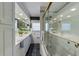 The bathroom features double sinks, lots of vanity counter space, an enclosed bath and shower, and black tile floors at 336 S Orchid Dr, Ellenton, FL 34222