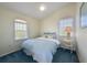 Bright bedroom featuring a comfortable bed with a blue quilt and a large window at 336 S Orchid Dr, Ellenton, FL 34222