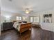 This bedroom boasts stylish hardwood floors, a ceiling fan, and a cozy sitting area near the bright windows at 336 S Orchid Dr, Ellenton, FL 34222
