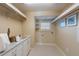 Bright laundry room with white cabinets, granite counters, washer/dryer hookups and utility sink at 336 S Orchid Dr, Ellenton, FL 34222
