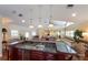 Open-concept wet bar with granite countertop, built-in sink, and view of the game room at 336 S Orchid Dr, Ellenton, FL 34222