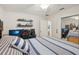 A bedroom with a modern striped bedspread, a ceiling fan, and a gaming setup with a computer at 3419 31St E St, Bradenton, FL 34208