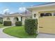 Charming home exterior with manicured landscaping, a yellow garage door, and an arched front entry at 3419 31St E St, Bradenton, FL 34208