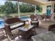 Relaxing covered patio with wicker furniture overlooking a sparkling pool and scenic lake view at 3419 31St E St, Bradenton, FL 34208
