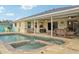Beautiful backyard pool and spa with brick surround, covered patio, and serene water views at 3419 31St E St, Bradenton, FL 34208