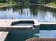 Tranquil view of the built-in hot tub and spillover into the pool, creating a serene backyard oasis overlooking a lake at 3419 31St E St, Bradenton, FL 34208