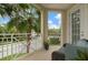 Charming balcony with comfortable blue seating overlooking lush landscaping and sunny skies at 3450 77Th W St # 103, Bradenton, FL 34209