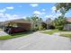 Exterior view of a tan home with a carport and well-maintained landscaping at 3461 Tallywood Cir # 7067, Sarasota, FL 34237