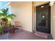 Inviting front porch with brick flooring, seating, and a 'Welcome' mat at the front door at 3461 Tallywood Cir # 7067, Sarasota, FL 34237