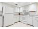 A well-lit kitchen with white appliances and cabinets at 3461 Tallywood Cir # 7067, Sarasota, FL 34237