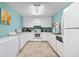 A modern kitchen with white appliances and cabinets, plus a bright blue wall at 3461 Tallywood Cir # 7067, Sarasota, FL 34237