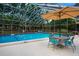 Enclosed swimming pool area featuring a pool, a table with chairs, and shaded seating at 3461 Tallywood Cir # 7067, Sarasota, FL 34237