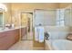 The bathroom features a luxurious soaking tub, separate vanities, and a glass-enclosed shower at 3712 59Th Avenue E Cir, Ellenton, FL 34222