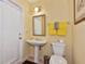 Bathroom featuring a pedestal sink, toilet, and walk-out door with bright yellow decor at 3712 59Th Avenue E Cir, Ellenton, FL 34222