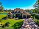 A beautiful waterfront home with a manicured lawn, lovely landscaping, and a brick driveway under a clear blue sky at 3712 59Th Avenue E Cir, Ellenton, FL 34222