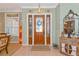 Light and bright foyer with tile flooring, a decorative mirror, and an eye-catching glass-paneled front door at 3712 59Th Avenue E Cir, Ellenton, FL 34222