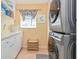 Well-equipped laundry room featuring a stacked washer/dryer, storage cabinets, and a window at 3712 59Th Avenue E Cir, Ellenton, FL 34222
